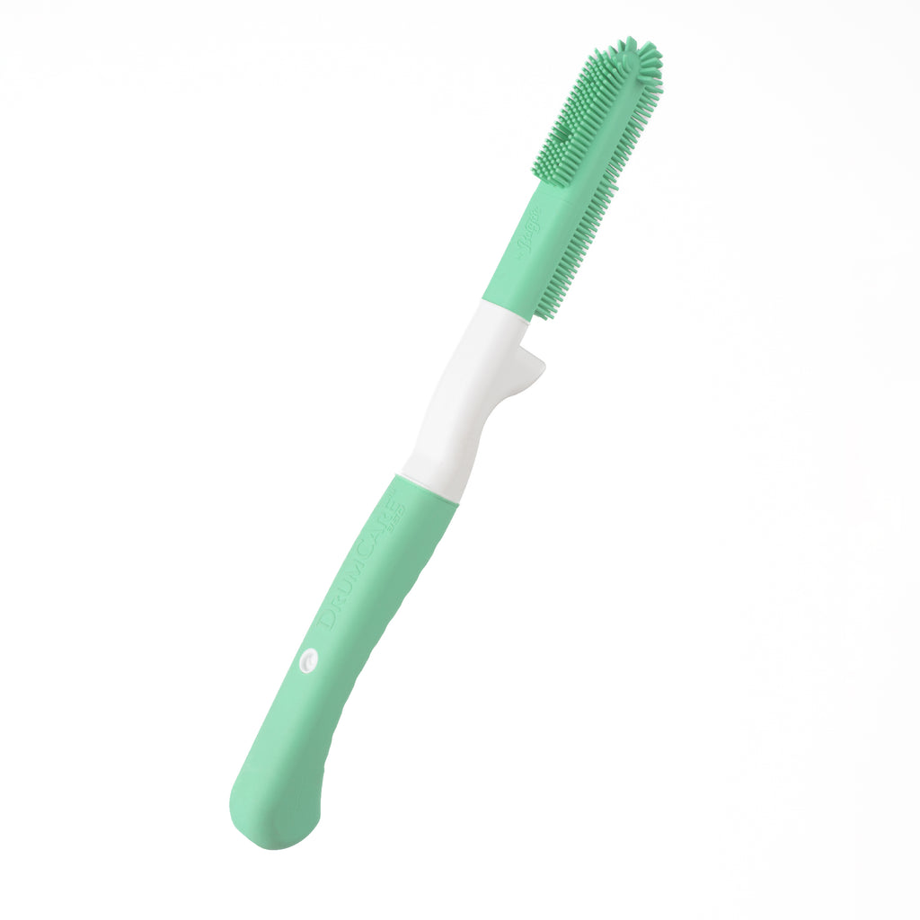 Green and white silicone brush on a white background